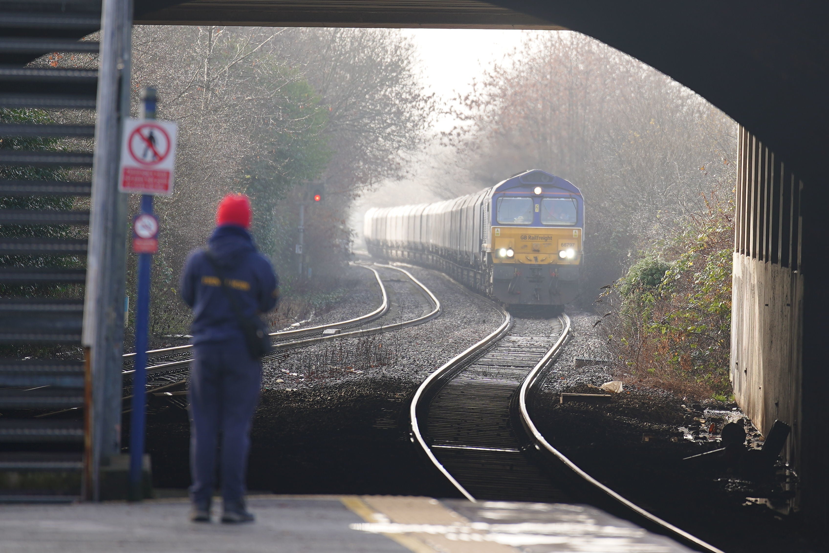 A passenger waits for a train at Denton railway station in Greater Manchester